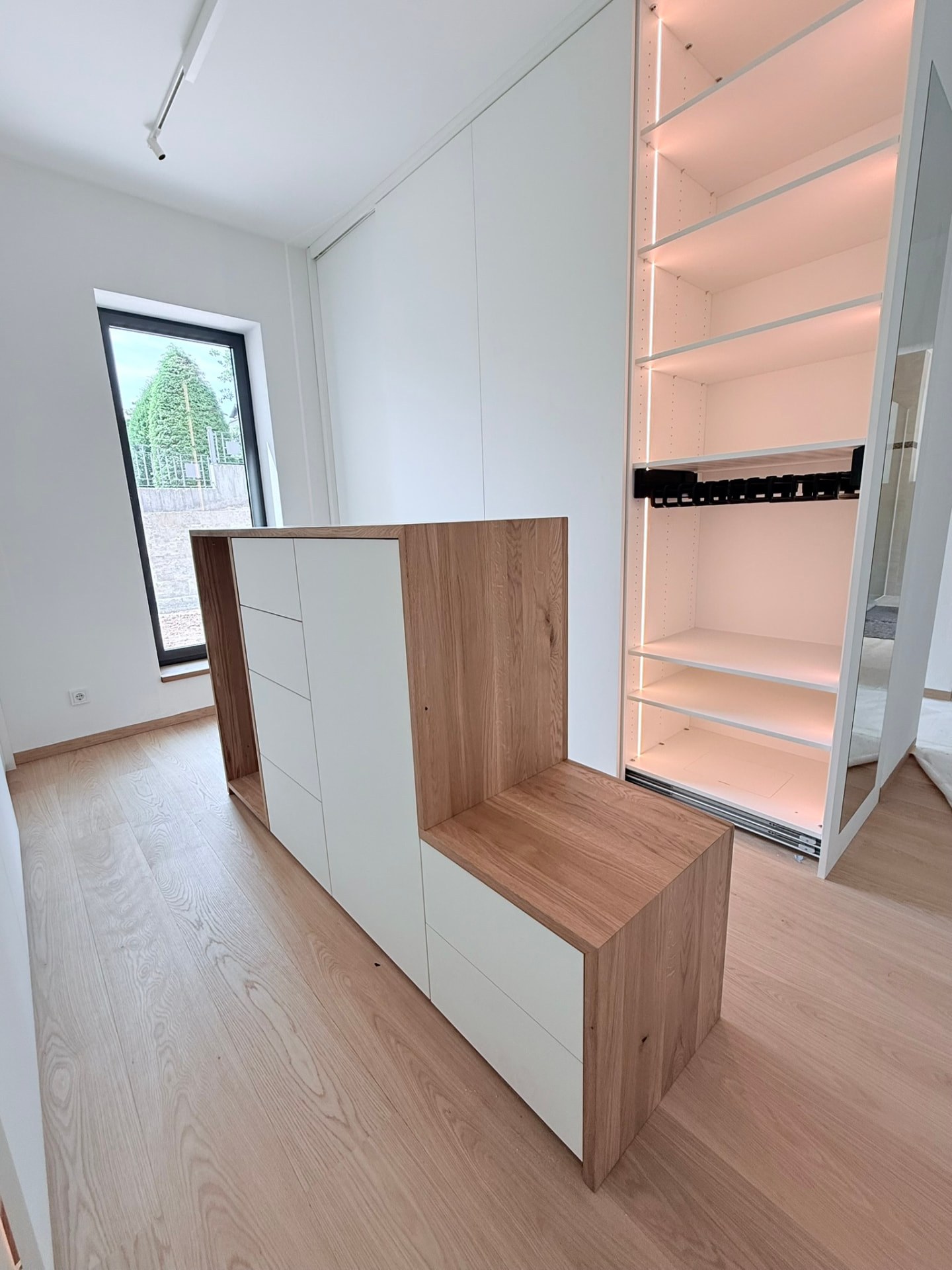 Ankleide mit Garderobenbank und beleuchtetem Schrank – Schreinerei Siegert
