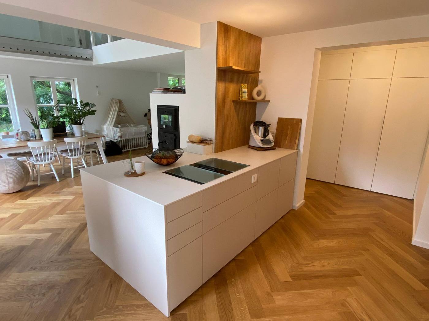 Helle maßgefertigte Küche mit Kochinsel und Holzregalen